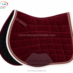 Burgundy quilted saddle pad with white plush edging, decorative patterned braid, and reinforced girth patch.